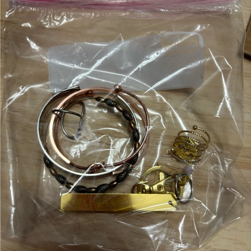 Bag of accessories, including an Alex and Ani bracelet